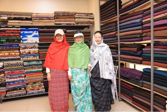 Chinese women delegates wear Somali shawls in Hayat Market’s textile section during a cultural exchange. Photo: Supplied
